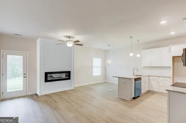 an empty room with windows and chandelier fan