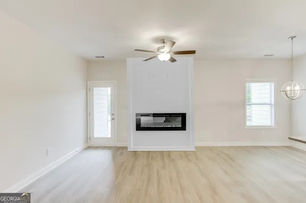 a large white kitchen with kitchen island a sink dishwasher a stove and a refrigerator with wooden floor