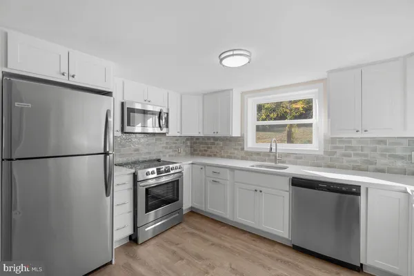 a kitchen with a sink a refrigerator a washer and dryer
