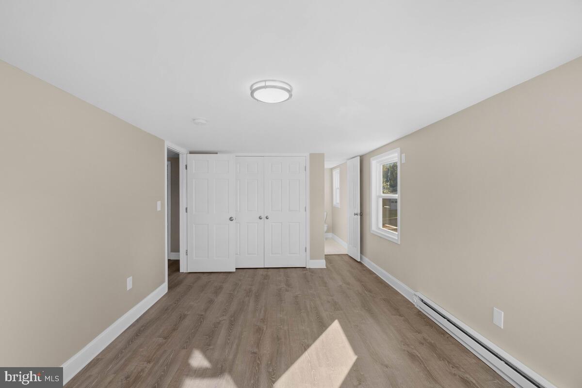 332 Ridge Road, Unit A Westminster, MD 21157 - Photo 9 of 21 an empty room with wooden floor and windows