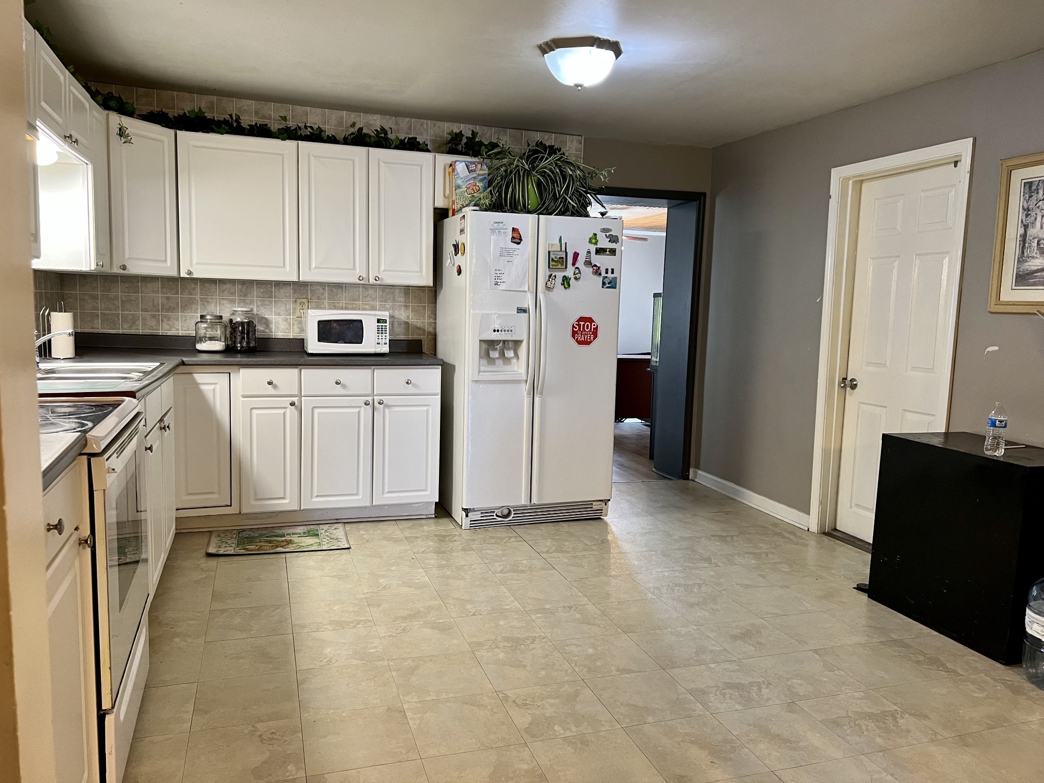 1076 Southside Road Southside, TN 37171 - Photo 5 of 27 a view of a kitchen with refrigerator and white cabinets