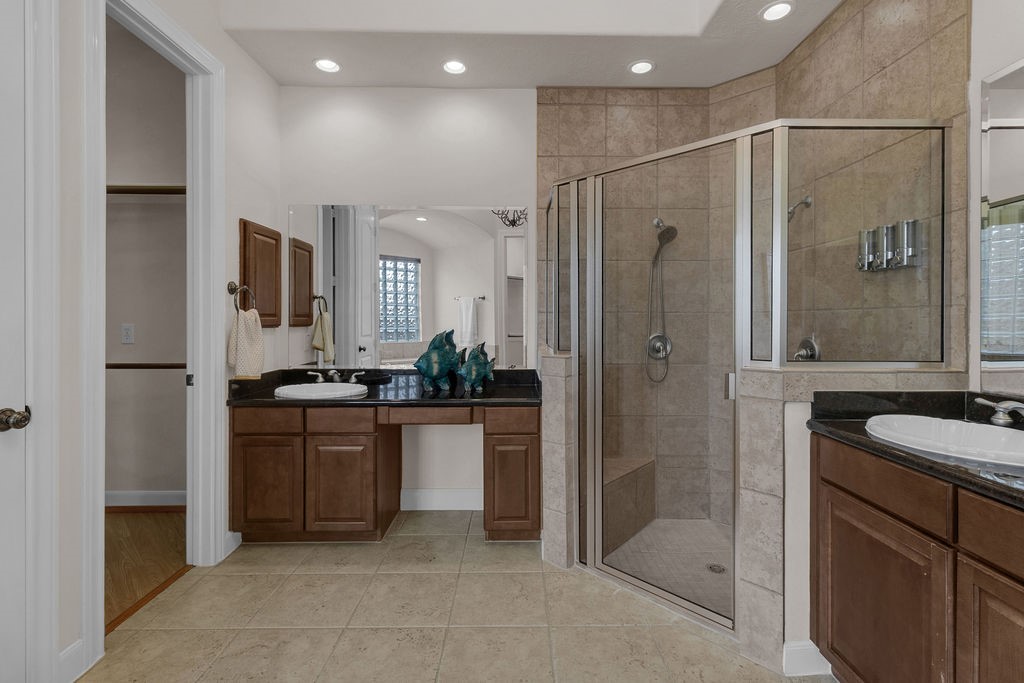7306 Starflower Katy, TX 77494 - Photo 29 of 50 a bathroom with a granite countertop sink mirror and shower