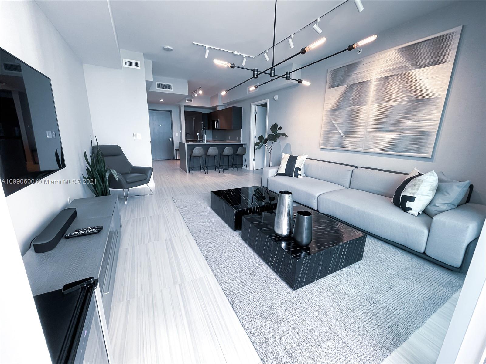 1080 Brickell Avenue, Unit 3702 Miami, FL 33131 - Photo 1 of 39 a living room with furniture and a flat screen tv