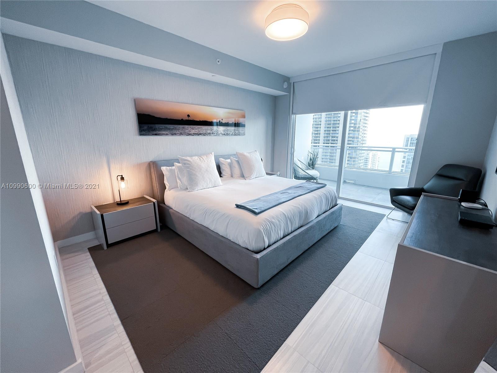 1080 Brickell Avenue, Unit 3702 Miami, FL 33131 - Photo 14 of 39 a bedroom with a bed lamp and a large window