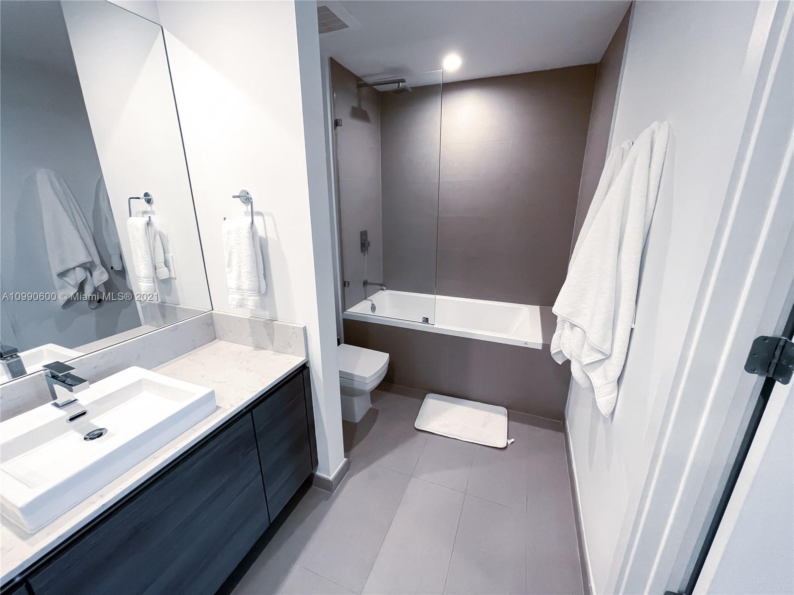 1080 Brickell Avenue, Unit 3702 Miami, FL 33131 - Photo 18 of 39 a bathroom with a sink a toilet and a mirror