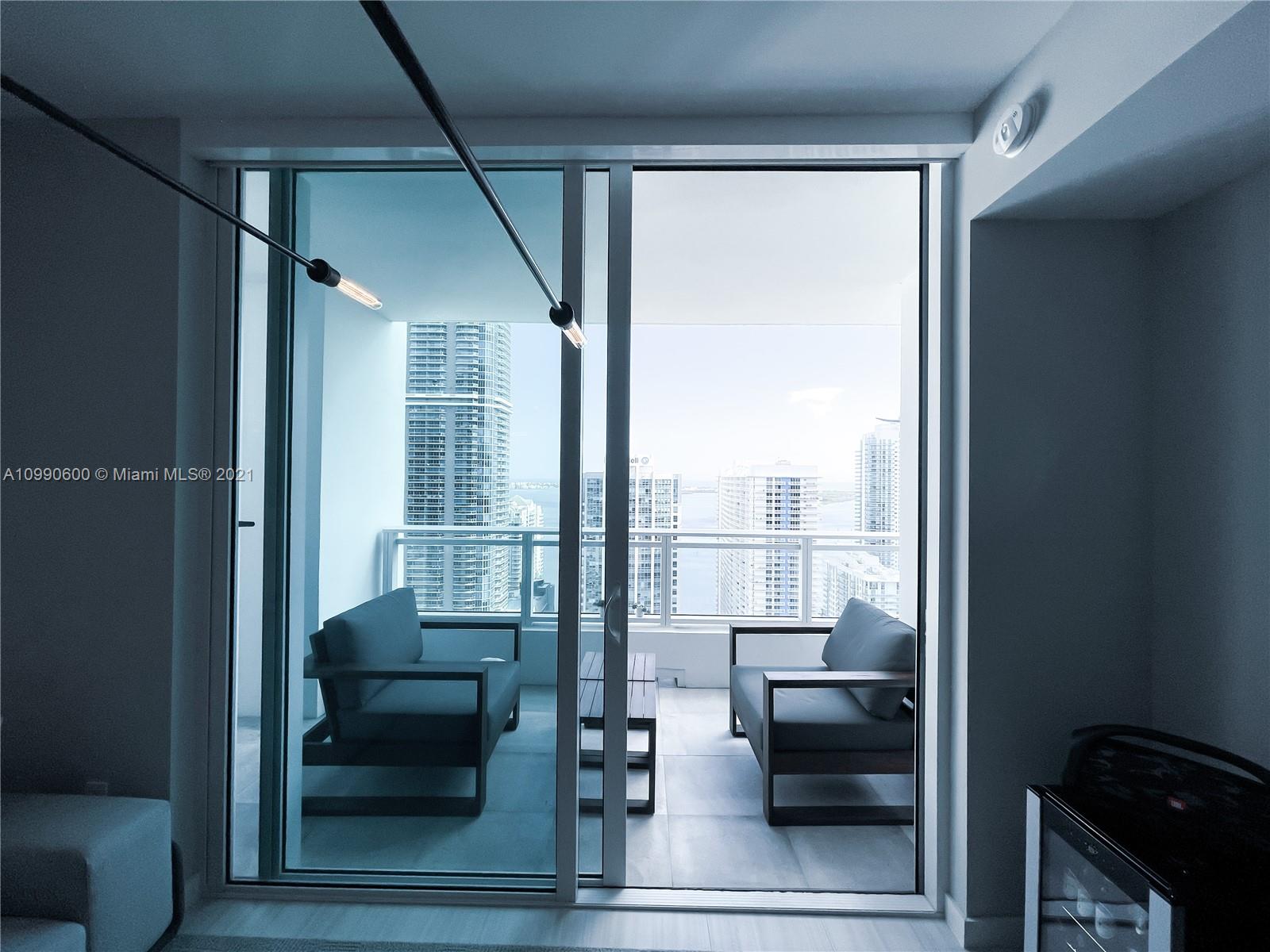 1080 Brickell Avenue, Unit 3702 Miami, FL 33131 - Photo 20 of 39 a living room with furniture and a floor to ceiling window