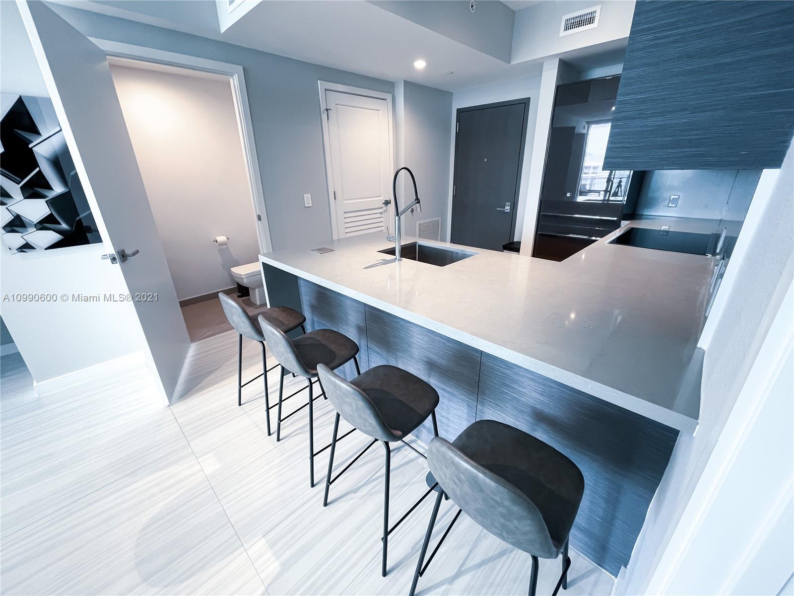1080 Brickell Avenue, Unit 3702 Miami, FL 33131 - Photo 3 of 39 a kitchen with a table chairs and refrigerator