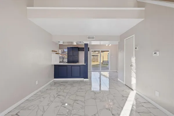 a room with kitchen island and stainless steel appliances