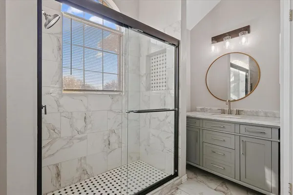 a bathroom with a double vanity sink a toilet a mirror and shower