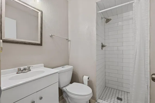 a bathroom with a sink a toilet and shower