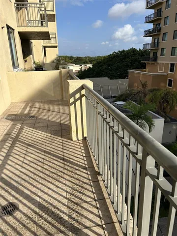a view of a balcony with wooden floor and fence