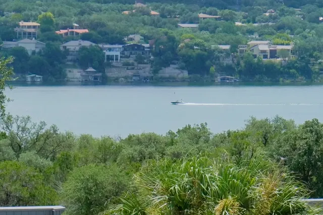 an aerial view of a residential houses with outdoor space and lake view
