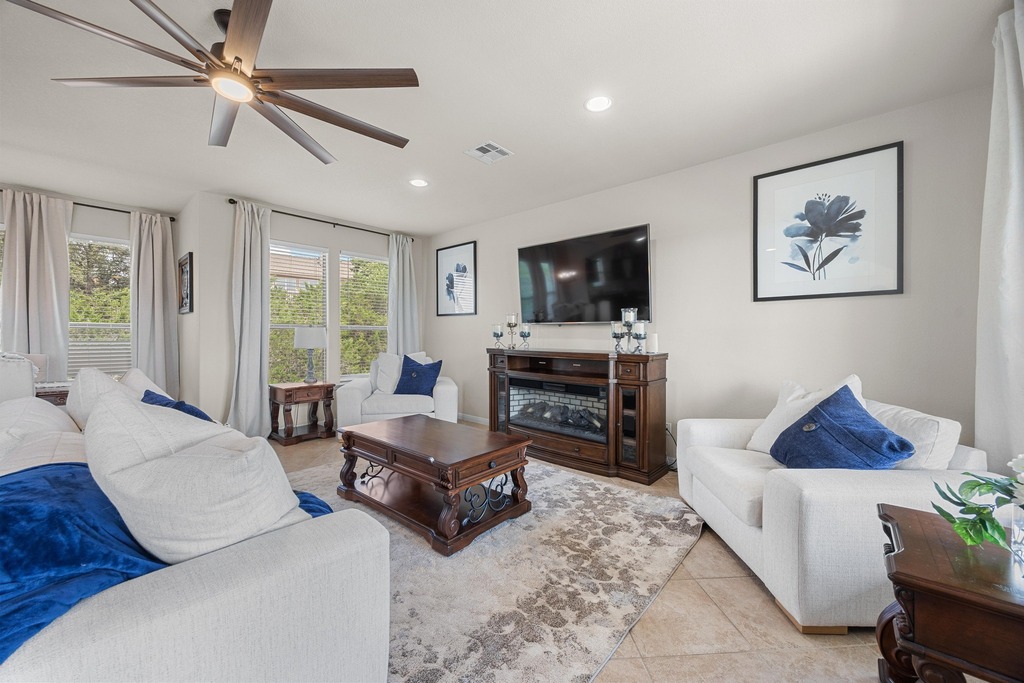 302 Southwind Road Lago Vista, TX 78645 - Photo 16 of 39 a living room with furniture a ceiling fan and a flat screen tv