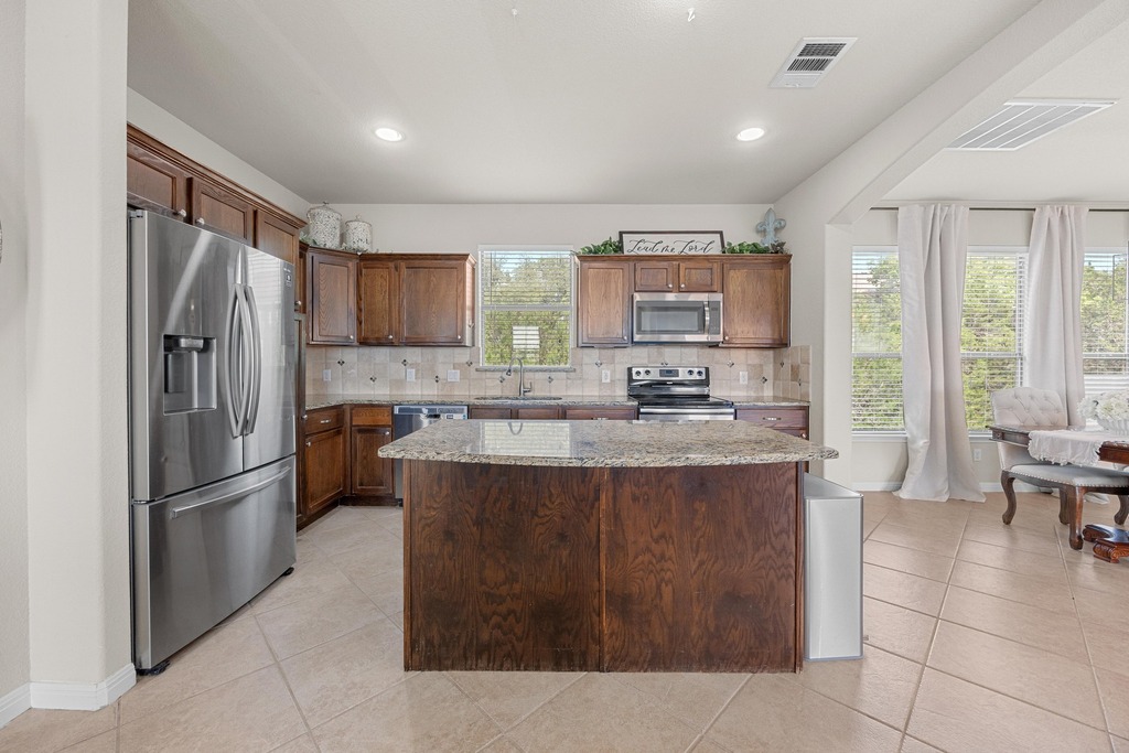 302 Southwind Road Lago Vista, TX 78645 - Photo 18 of 39 a kitchen with stainless steel appliances granite countertop a refrigerator and a stove top oven