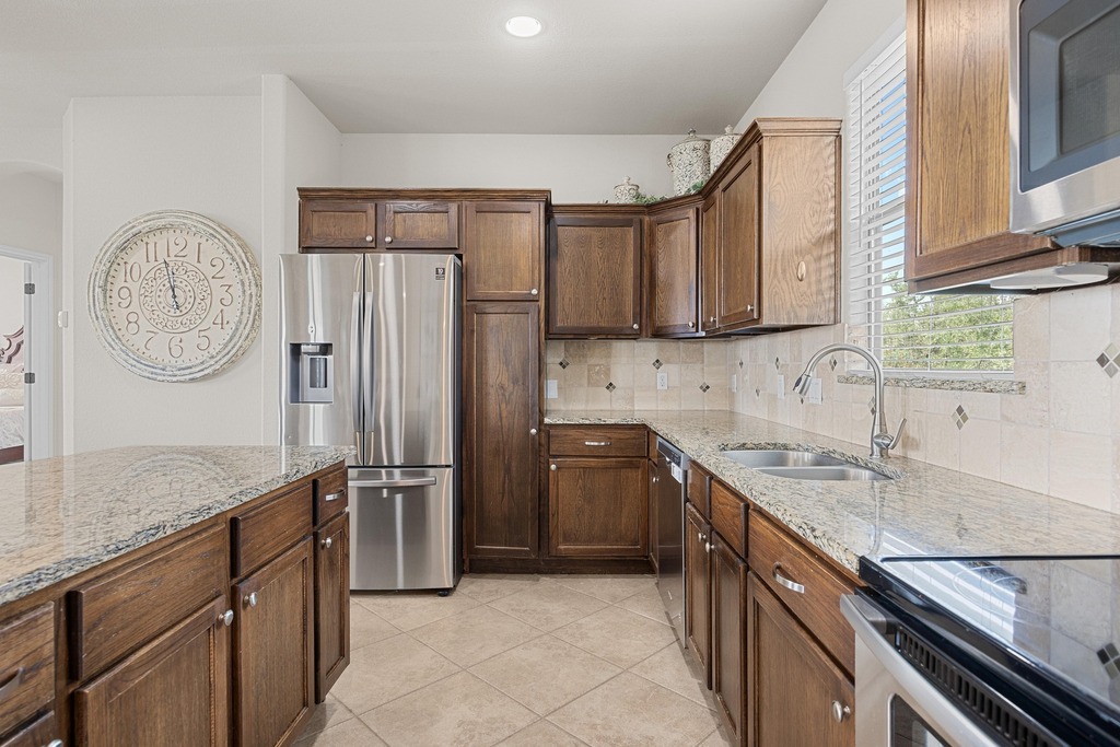 302 Southwind Road Lago Vista, TX 78645 - Photo 19 of 39 a kitchen with stainless steel appliances granite countertop a refrigerator a sink and a stove