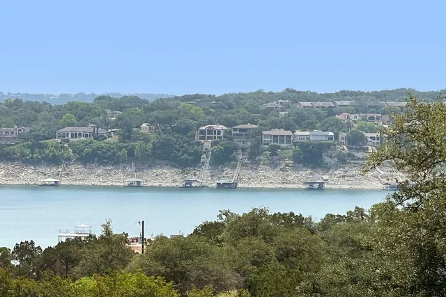 an aerial view of residential houses with outdoor space and lake view