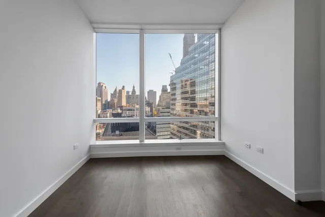 a large white kitchen with a large window and stainless steel appliances