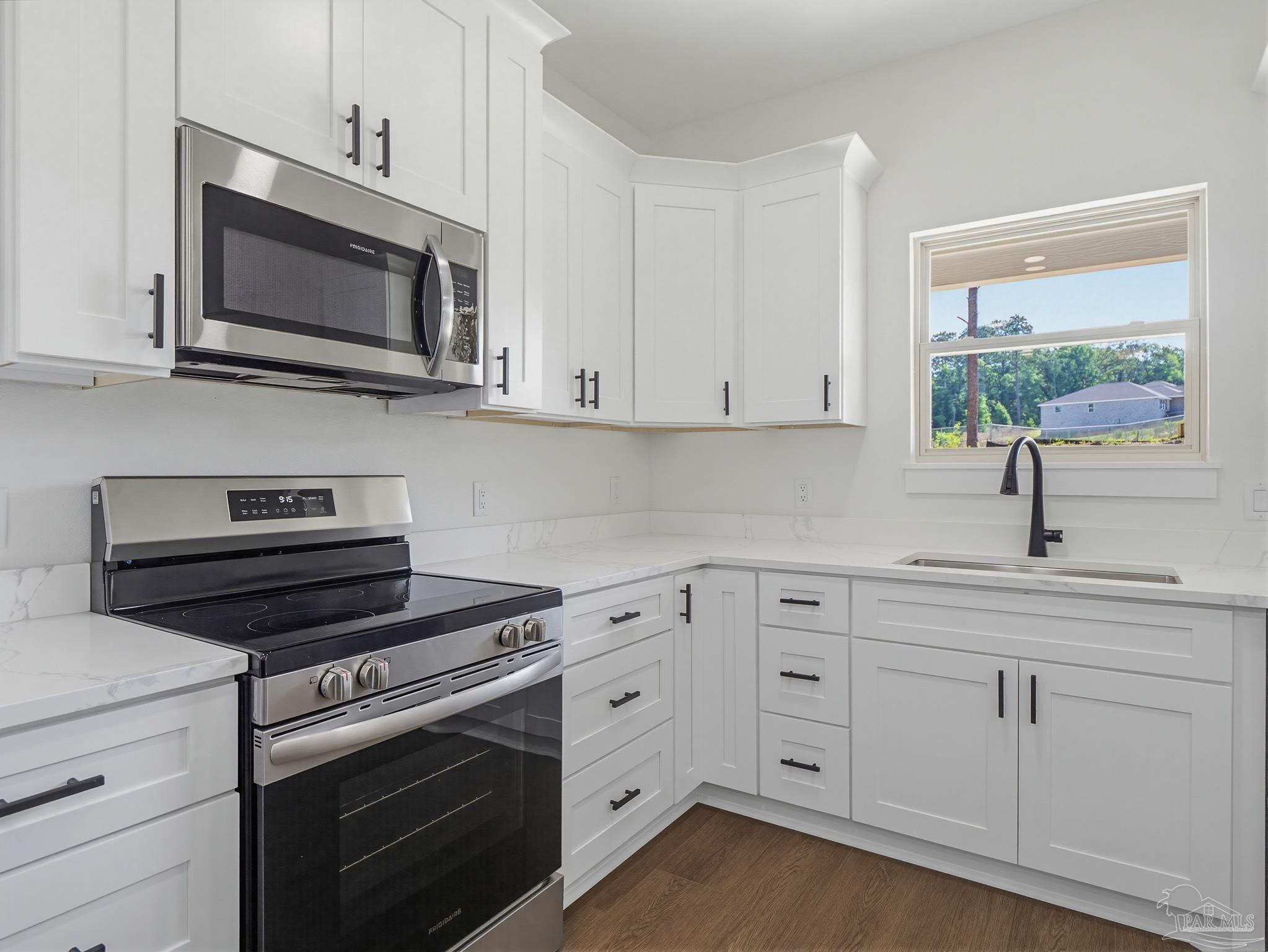 5724 Riviera Drive Milton, FL 32583 - Photo 2 of 52 a kitchen with white cabinets and appliances