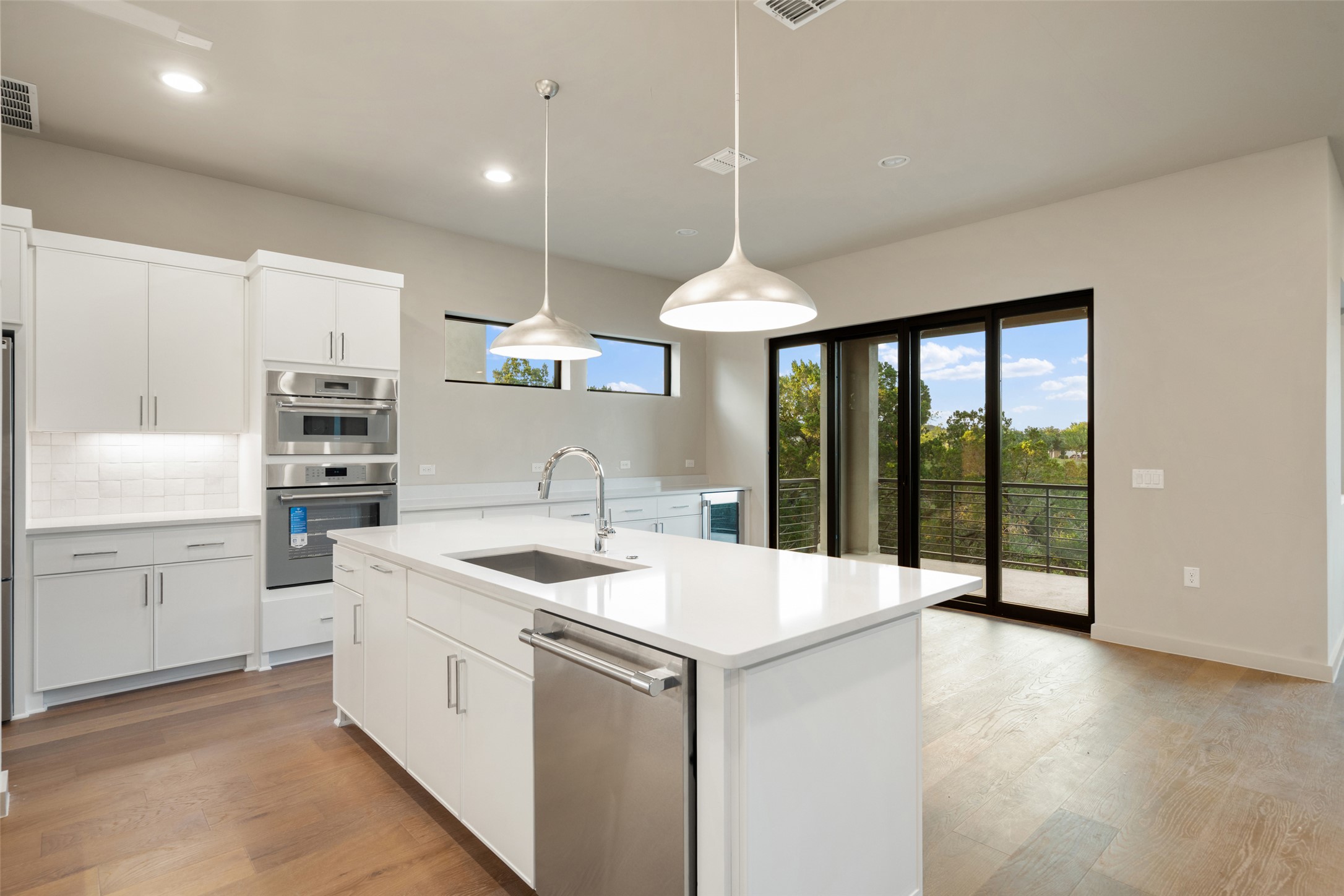 9803 Ribelin Ranch Court, Unit 16 Austin, TX 78750 - Photo 4 of 31 Gleaming wood floors and a large center island anchor this open-concept culinary space.