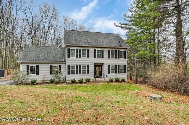 a front view of house with yard and trees around