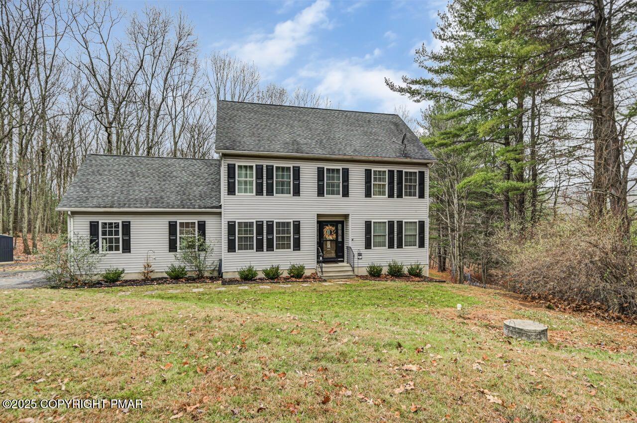 a front view of house with yard and trees around