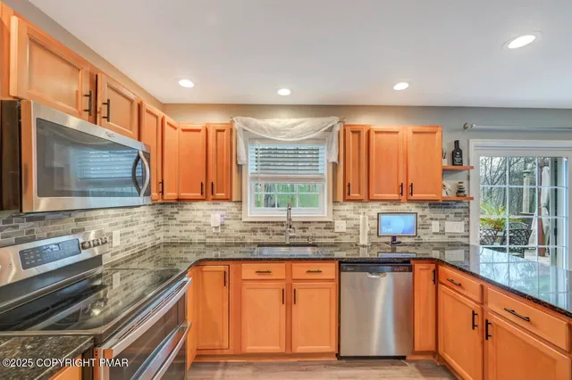 a kitchen with granite countertop a sink and a stove