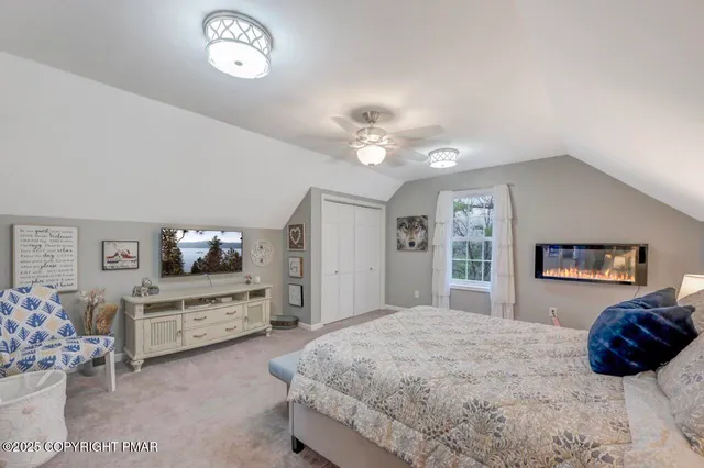 a spacious bedroom with a large bed and a chandelier