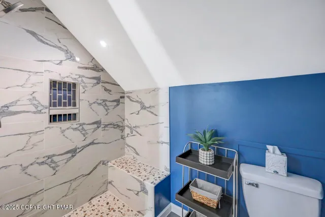 a bathroom with a toilet a sink and mirror