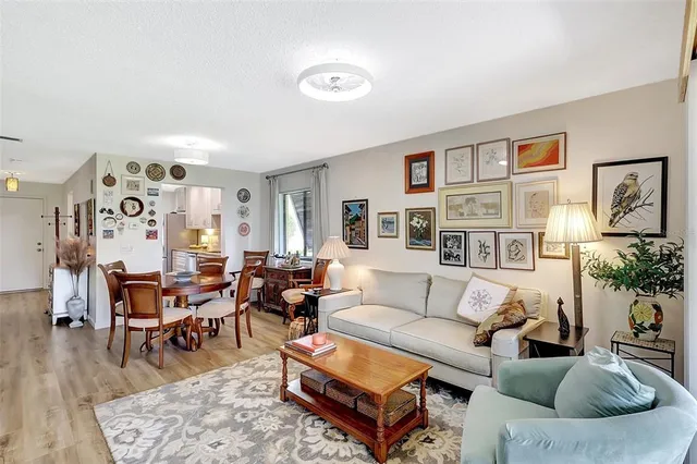 a living room with furniture a flat screen tv and floor to ceiling window