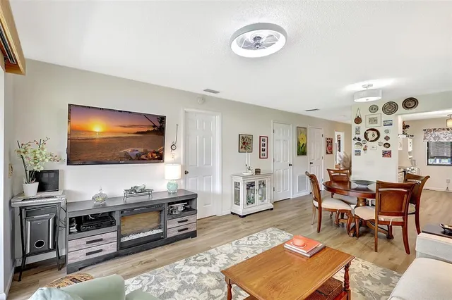 a living room with furniture wooden floor and a flat screen tv