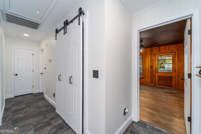 a view of a hallway with wooden floor and closet