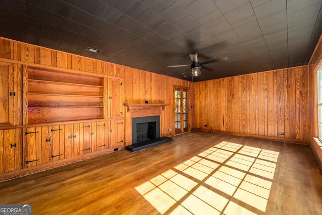 a view of an empty room with a fireplace and a window