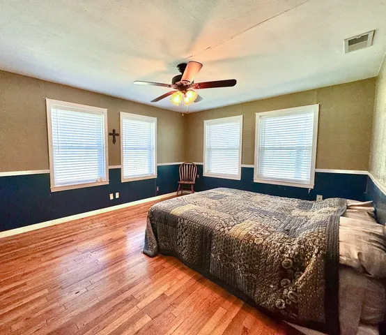 a bedroom with a large bed and a chandelier