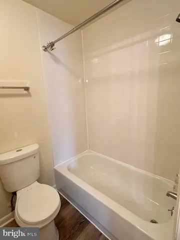 a white toilet sitting next to a bath tub