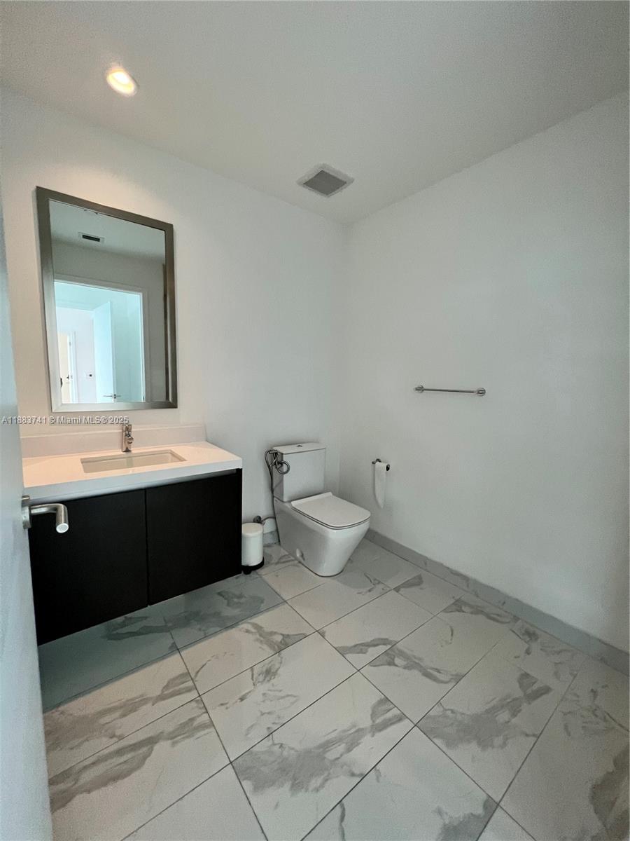 851 Northeast 1st Avenue, Unit 1208 Miami, FL 33132 - Photo 17 of 26 a spacious bathroom with a bathtub sink mirror and toilet