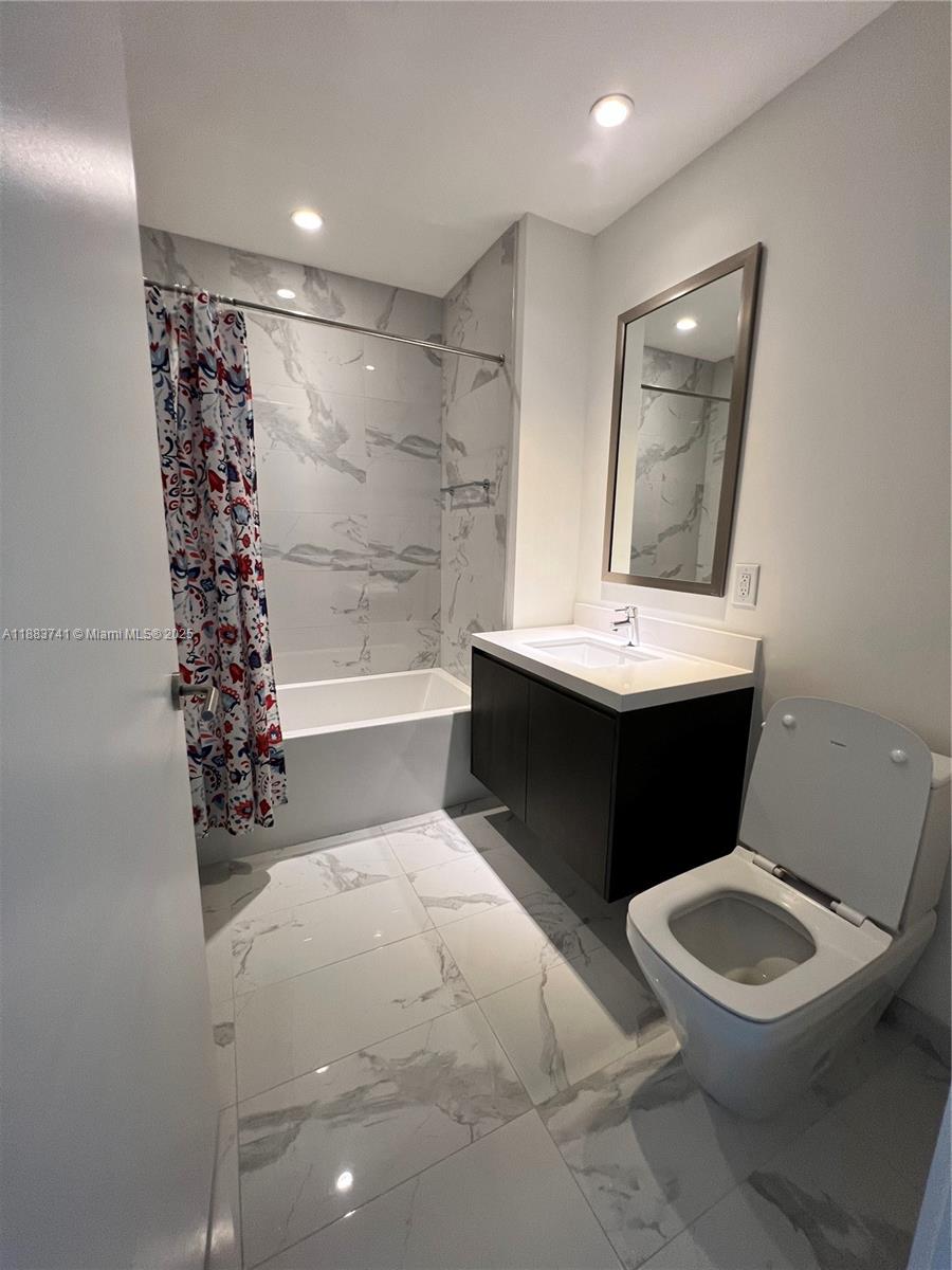 851 Northeast 1st Avenue, Unit 1208 Miami, FL 33132 - Photo 24 of 26 a bathroom with a sink a toilet and shower