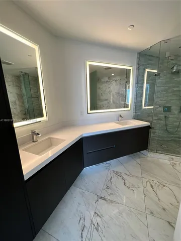 a bathroom with a granite countertop sink a bathtub and shower