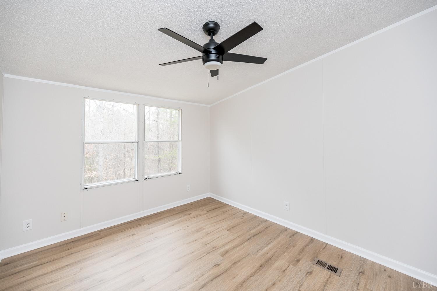 1636 Maddox Road Gladys, VA 24554 - Photo 28 of 54 an empty room with wooden floor and ceiling fan