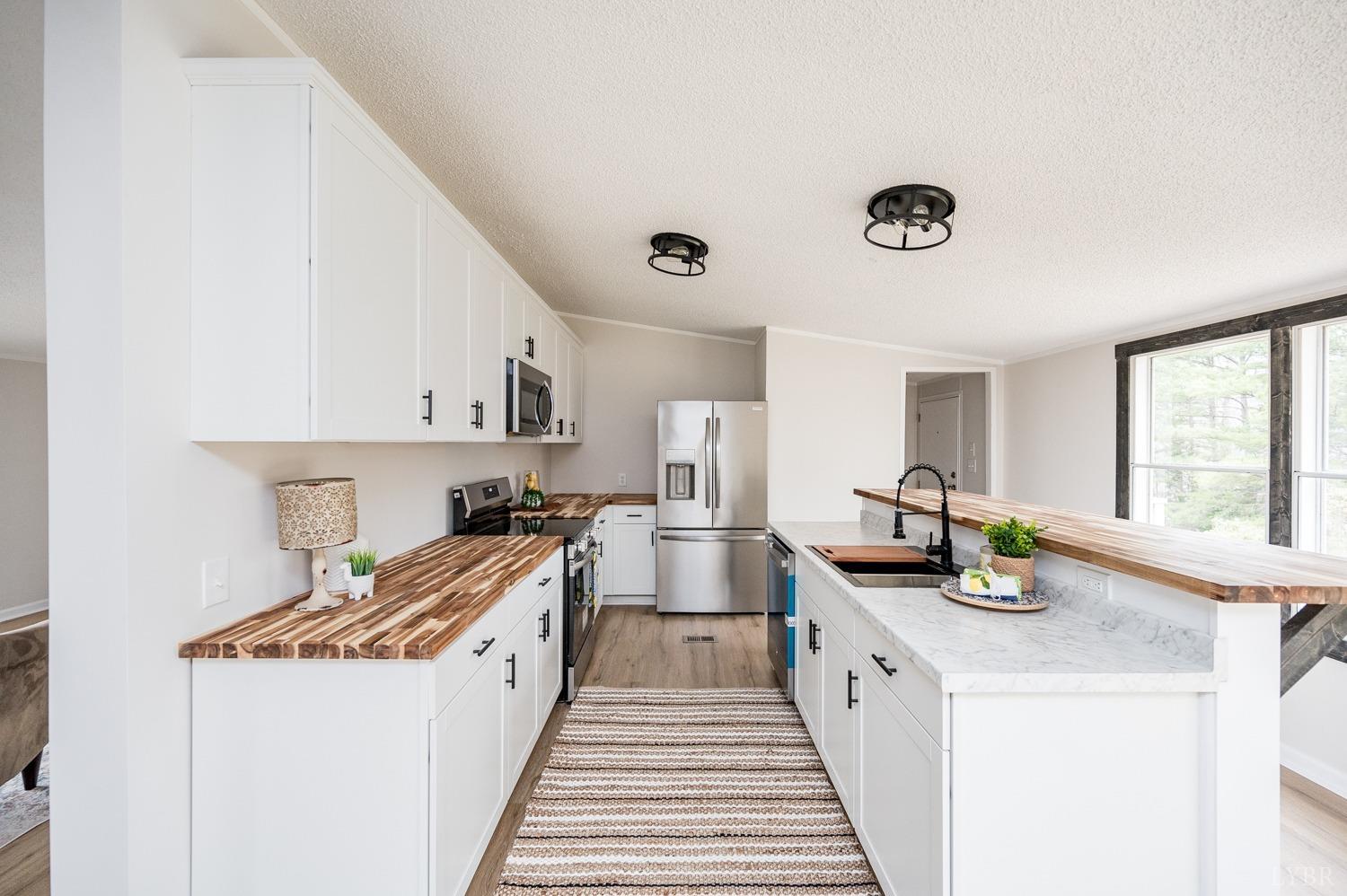 1636 Maddox Road Gladys, VA 24554 - Photo 5 of 54 a kitchen with sink a stove and wooden cabinets