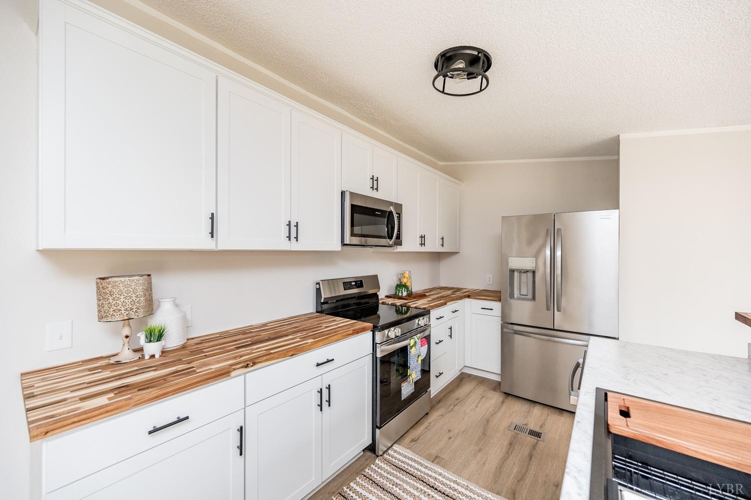 1636 Maddox Road Gladys, VA 24554 - Photo 6 of 54 a kitchen with granite countertop a refrigerator a sink stainless steel appliances and cabinets
