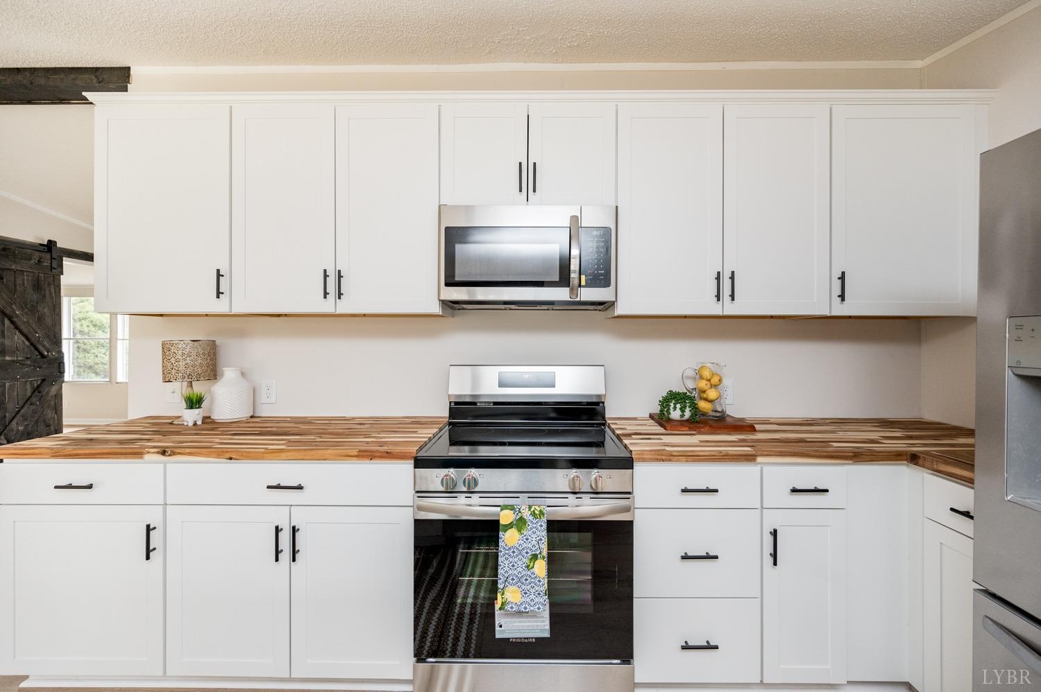 1636 Maddox Road Gladys, VA 24554 - Photo 10 of 54 a kitchen with granite countertop a stove a sink and a white cabinets