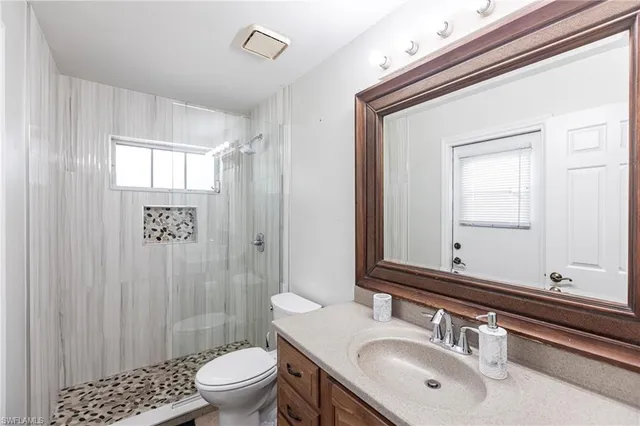 a bathroom with a sink a toilet and shower