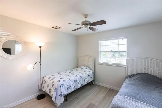 a bedroom with a bed next to a window with a chandelier