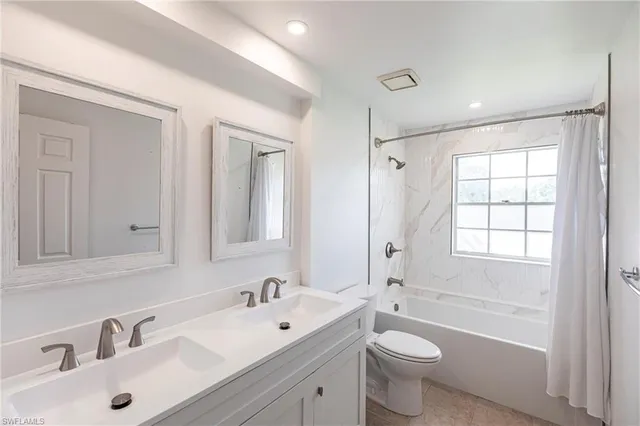 a bathroom with a toilet a sink a mirror a bathtub and shower