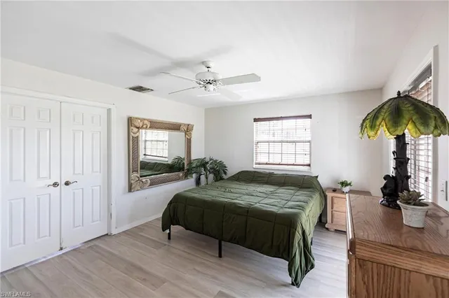 a bed sitting in a spacious bedroom next to a window