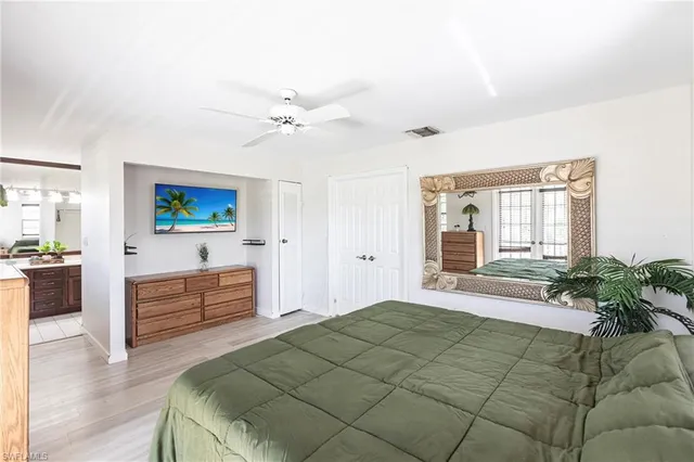a spacious bedroom with a bed and a dresser