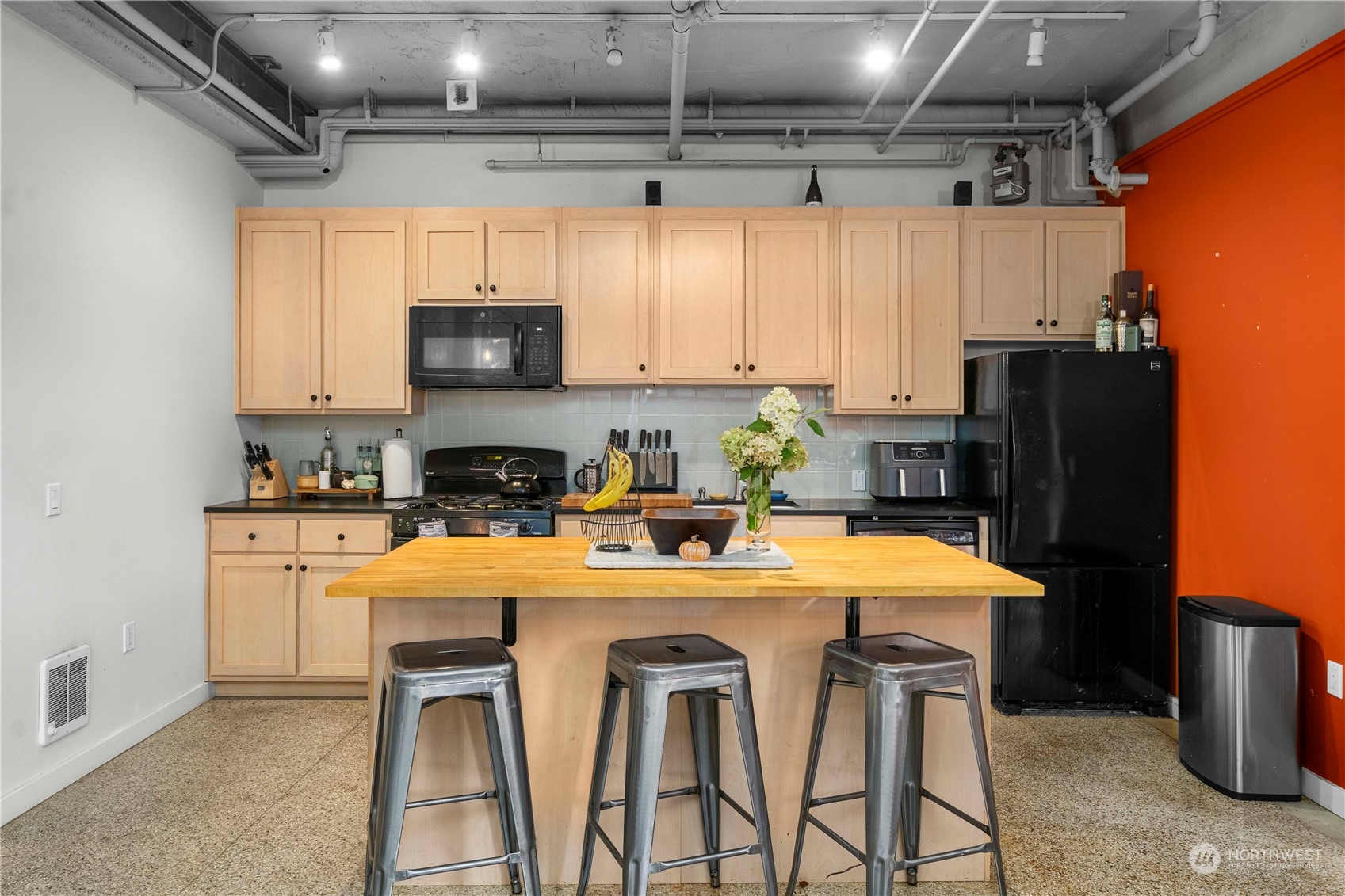 744 Market Street, Unit 302 Tacoma, WA 98402 - Photo 8 of 28 a kitchen with stainless steel appliances a table chairs and a refrigerator