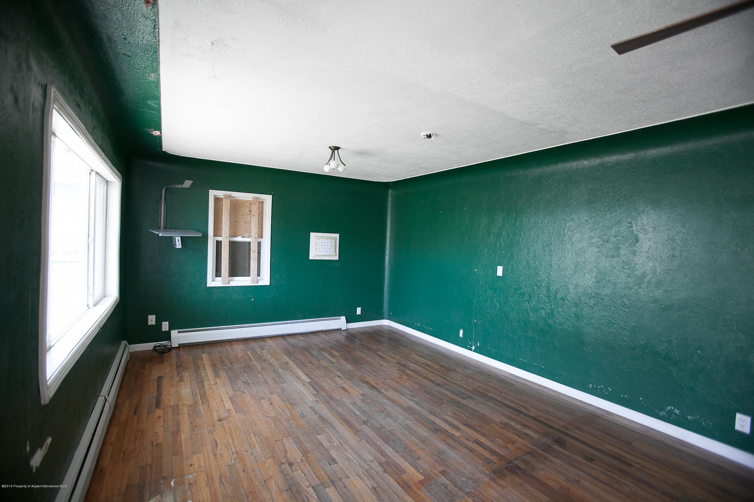 132 Ray Avenue Rifle, CO 81650 - Photo 2 of 10 a view of an empty room with wooden floor and a window