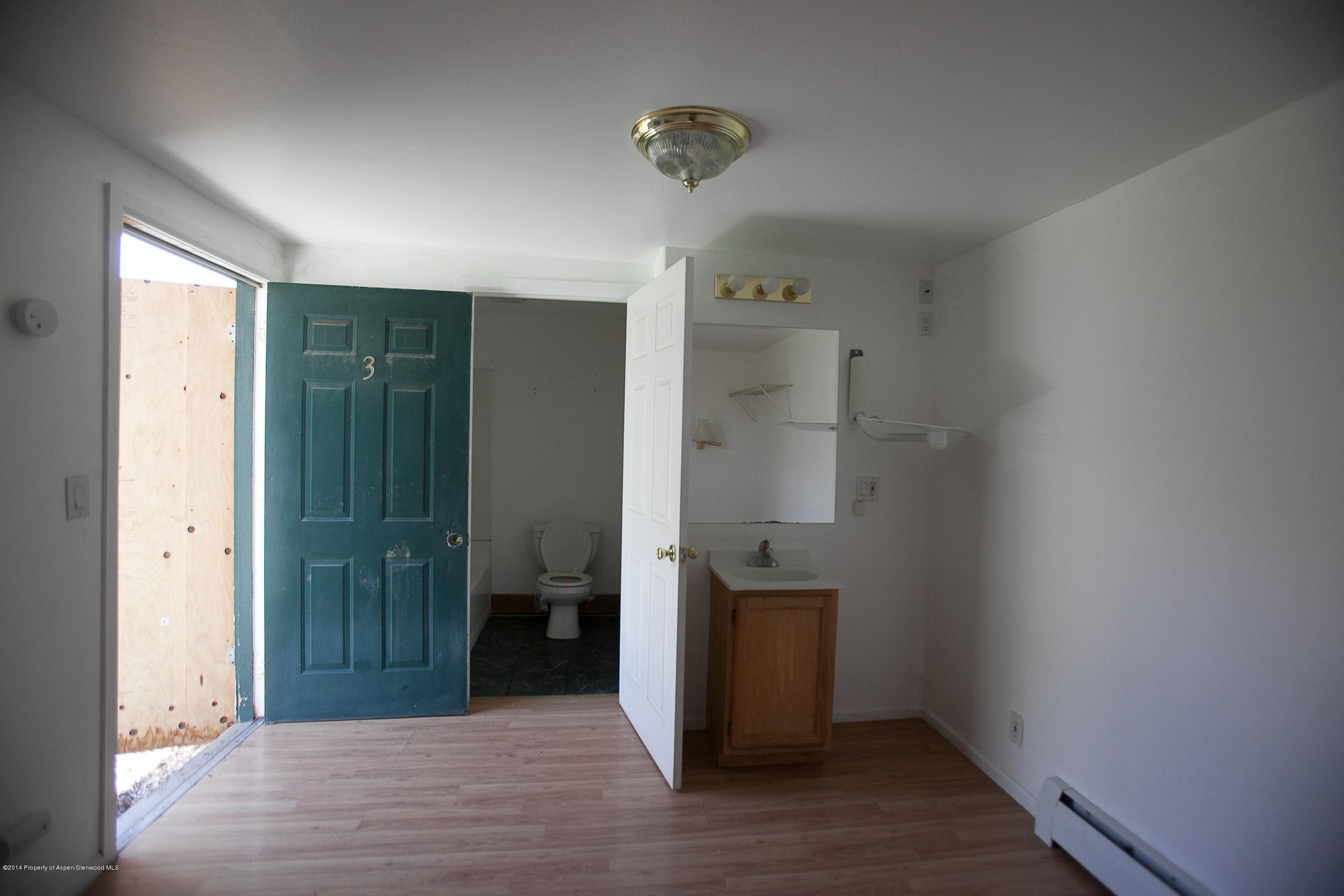 132 Ray Avenue Rifle, CO 81650 - Photo 7 of 10 a view of a hallway with wooden floor and a bathroom