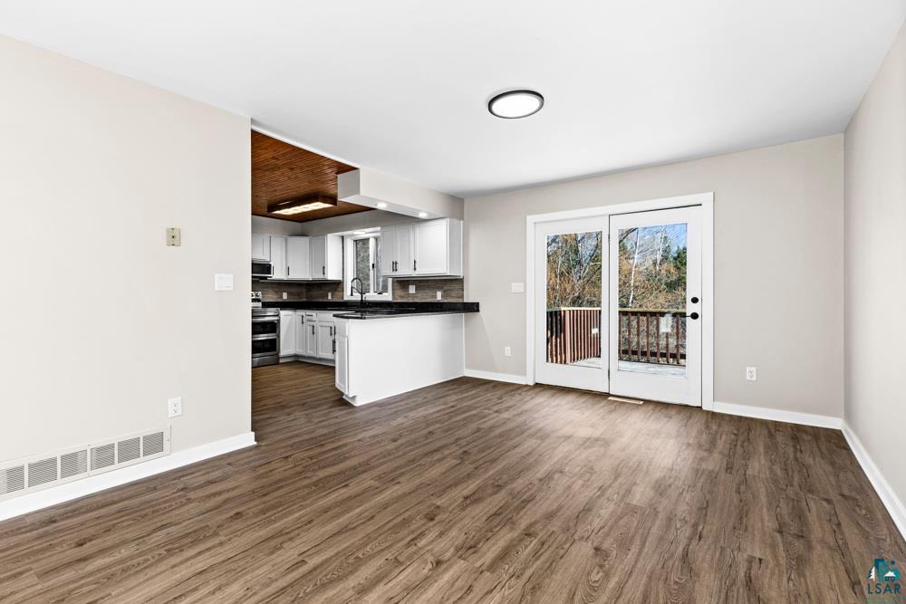 1148 Shoreview Road Two Harbors, MN 55616 - Photo 12 of 48 Kitchen with stainless steel appliances, tasteful backsplash, dark hardwood / wood-style floors, kitchen peninsula, and white cabinets